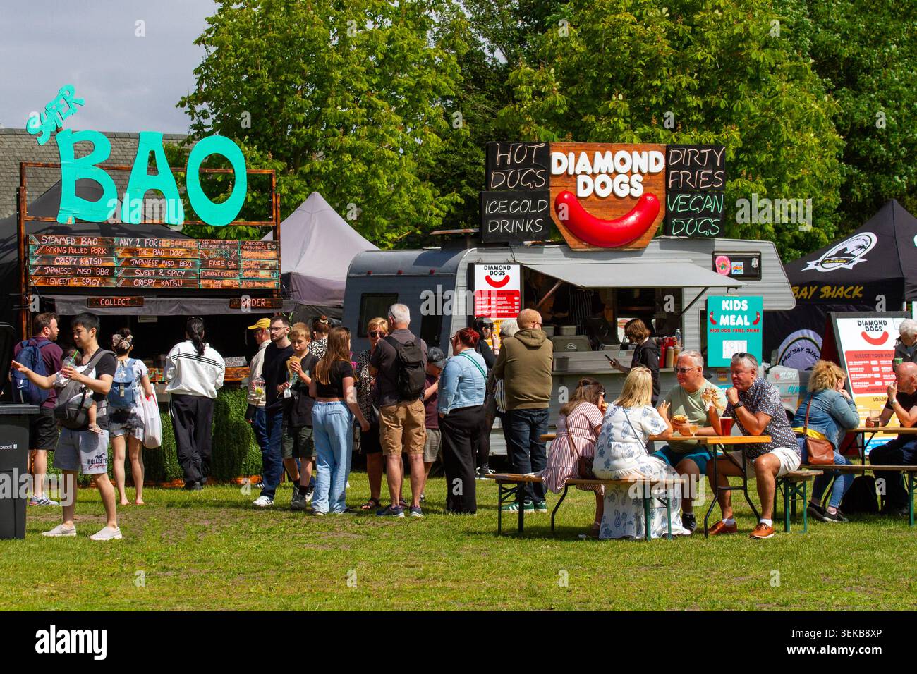 La gente fa la fila per ordinare dai camioncini ristorante "Super Bao" e "Diamond Dogs" a un festival all'aperto. Southport, Regno Unito. Foto Stock