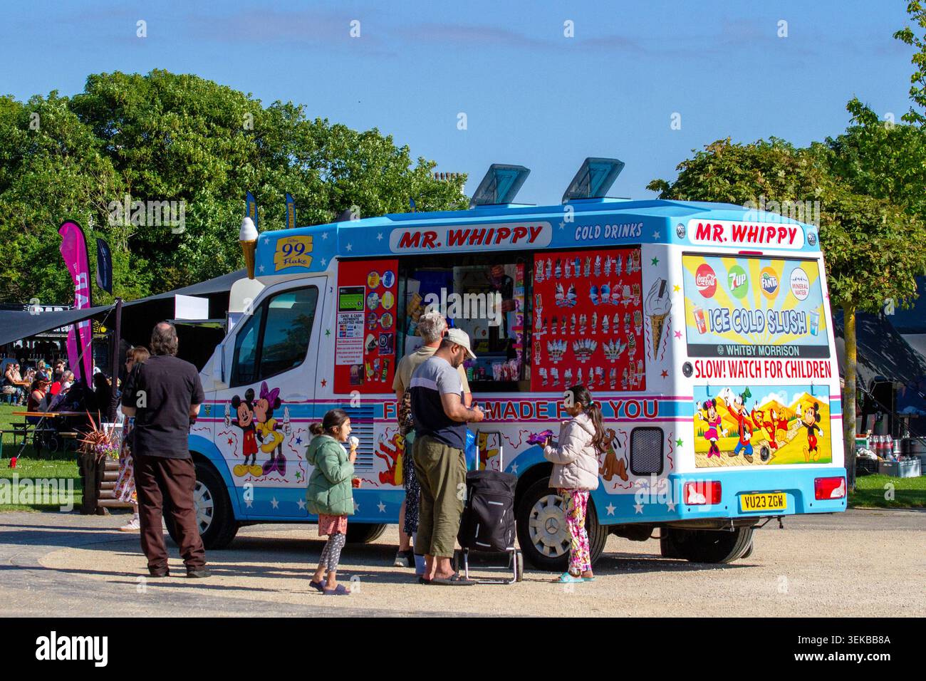 Un classico chiosco di gelato Mr Whippy parcheggiato a un evento all'aperto con clienti in fila per acquistare coni di gelato morbido e bevande fredde. Southport, Regno Unito. Foto Stock
