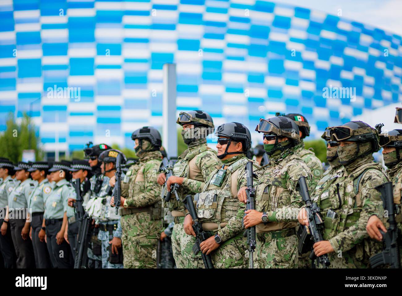 Il personale militare armato che indossa attrezzature mimetiche tattiche si trova in formazione per la sicurezza durante un evento sportivo di massa allo stadio Foto Stock