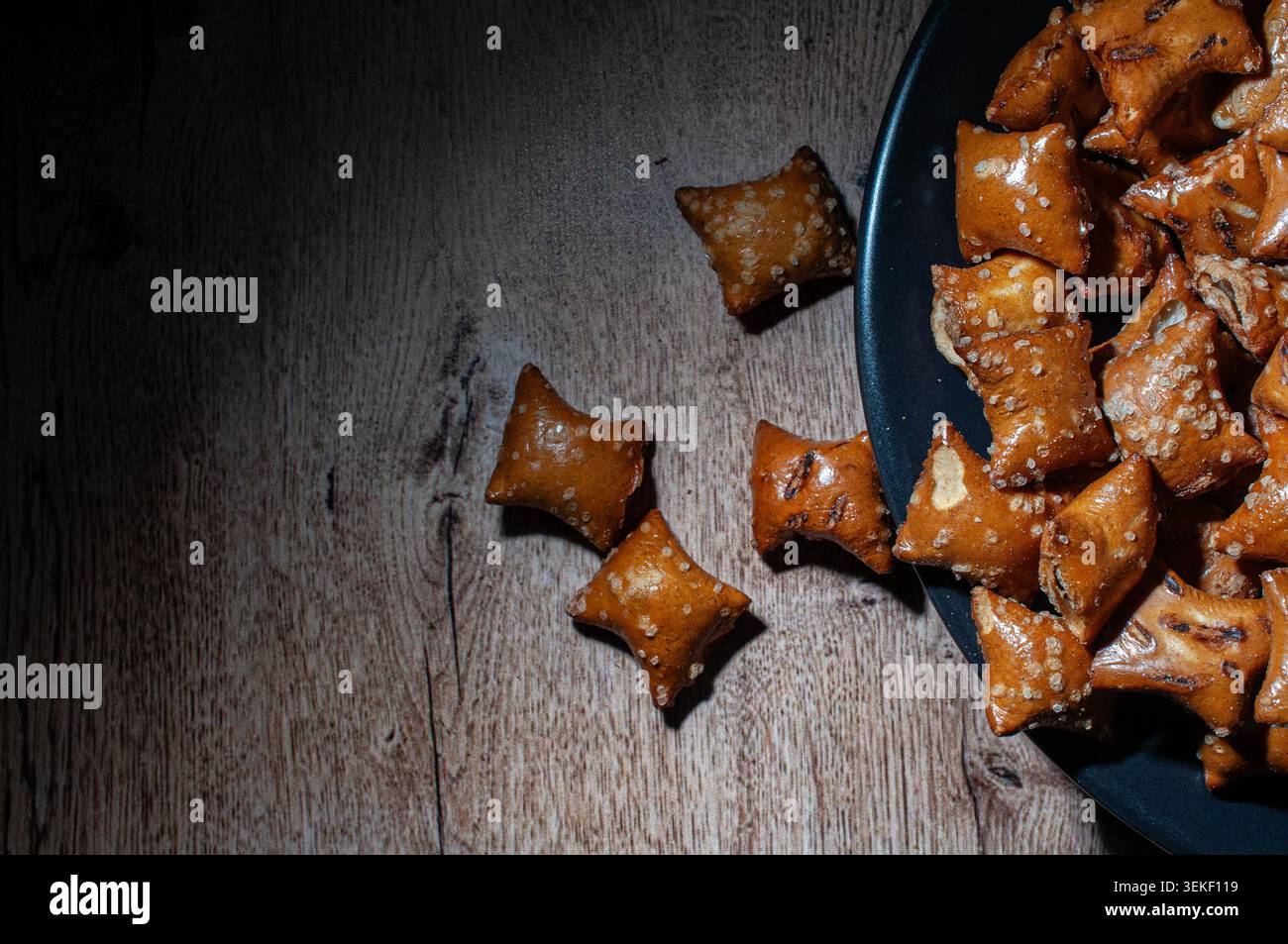 Pretzel a cubetti ripieni di burro di arachidi su un piatto nero su un rustico tavolo di legno. piano, vista dall'alto, spazio copia scuro, riempito di cioccolato e yogur Foto Stock
