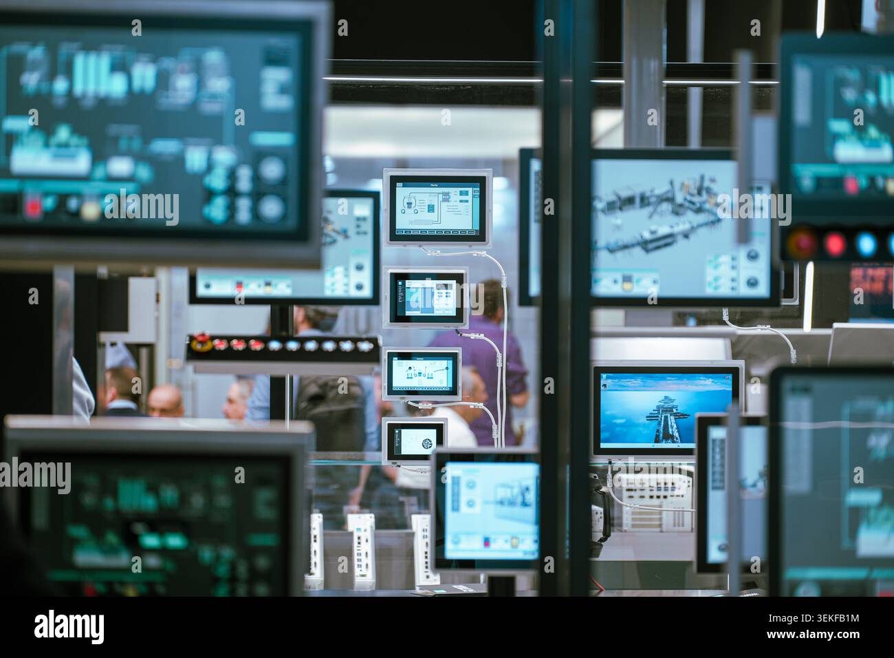 Diversi schermi del pannello di controllo industriale e display dell'interfaccia uomo-macchina (HMI) mostrano i dati del software di monitoraggio durante una tecnologia di automazione Foto Stock