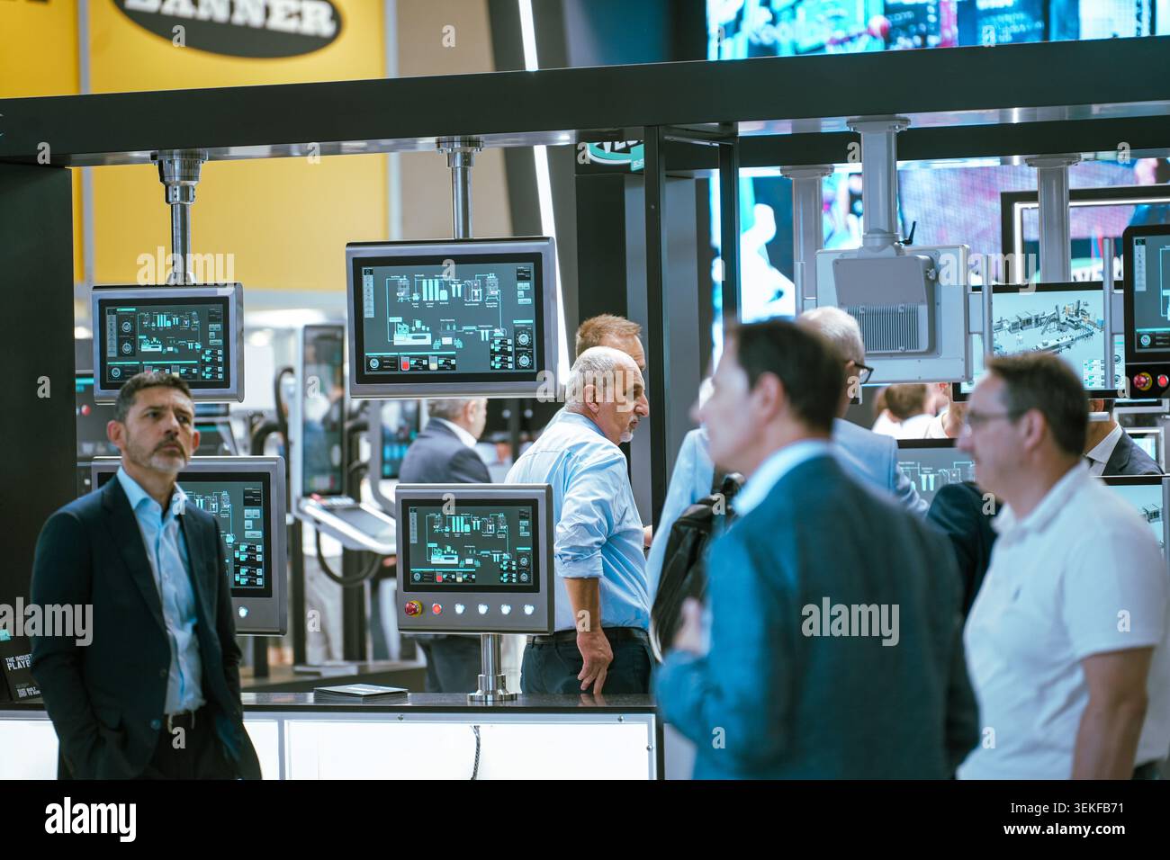 Diversi schermi dei terminali di controllo industriali visualizzano il software di monitoraggio attivo e i diagrammi logistici dei processi durante un commercio di tecnologie di automazione Foto Stock