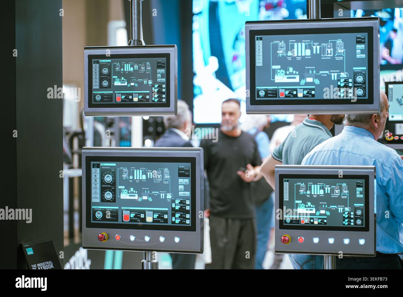 Diversi schermi dei terminali di controllo industriali visualizzano il software di monitoraggio attivo e i diagrammi logistici dei processi durante un commercio di tecnologie di automazione Foto Stock