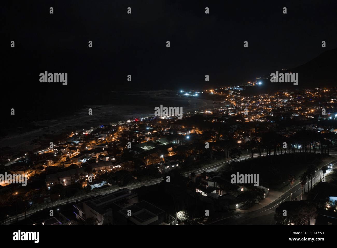 Vista aerea notturna della costa Camps Bay di città del Capo con una strada tortuosa Foto Stock