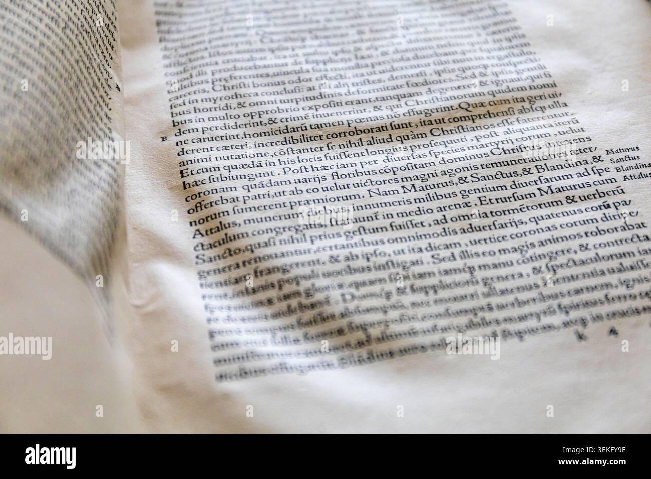 Vista ravvicinata di un libro antico che mostra il testo latino stampato su carta invecchiata. Foto Stock