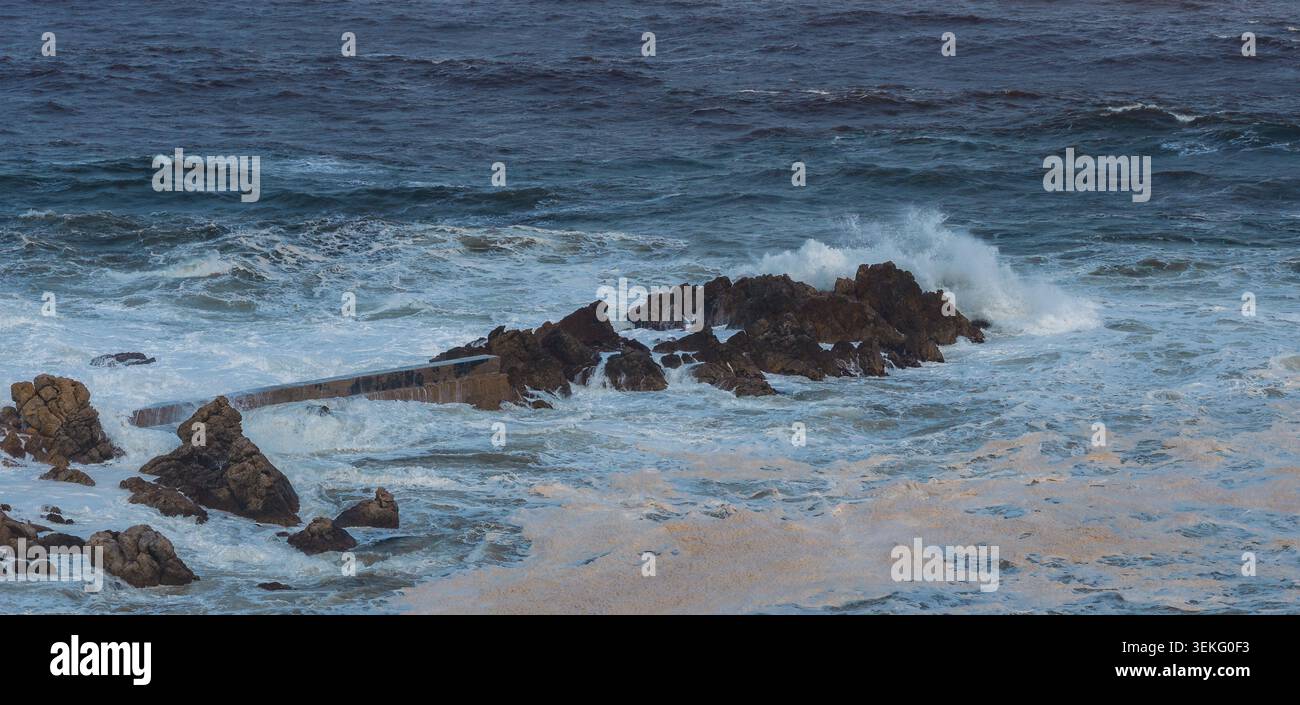 Le onde si infrangono su rocce frastagliate lungo la penisola del Capo, vicino a città del Capo Foto Stock