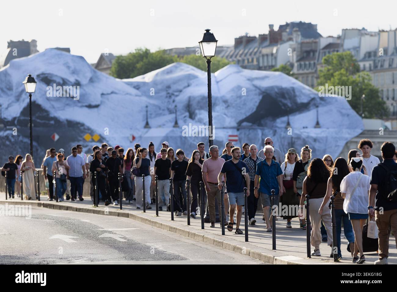 La folla cammina lungo la Senna a Parigi, in Francia, con un'installazione su larga scala in stile Christo visibile sullo sfondo. Foto Stock