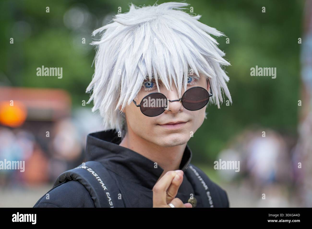 Un ritratto ravvicinato di un cosplayer vestito come il personaggio Satoru Gojo di Jujutsu Kaisen, con una parrucca bianca spessa, lenti a contatto blu brillante, Foto Stock