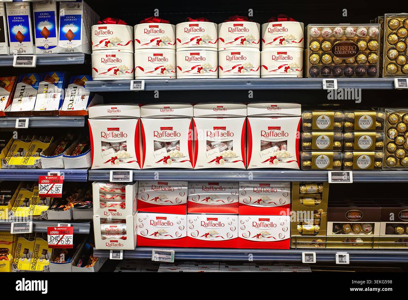 Batumi, Georgia - 30 maggio 2026: Vetrina di negozi di alimentari con cioccolatini Raffaello e Ferrero Rocher in scatola. Foto Stock