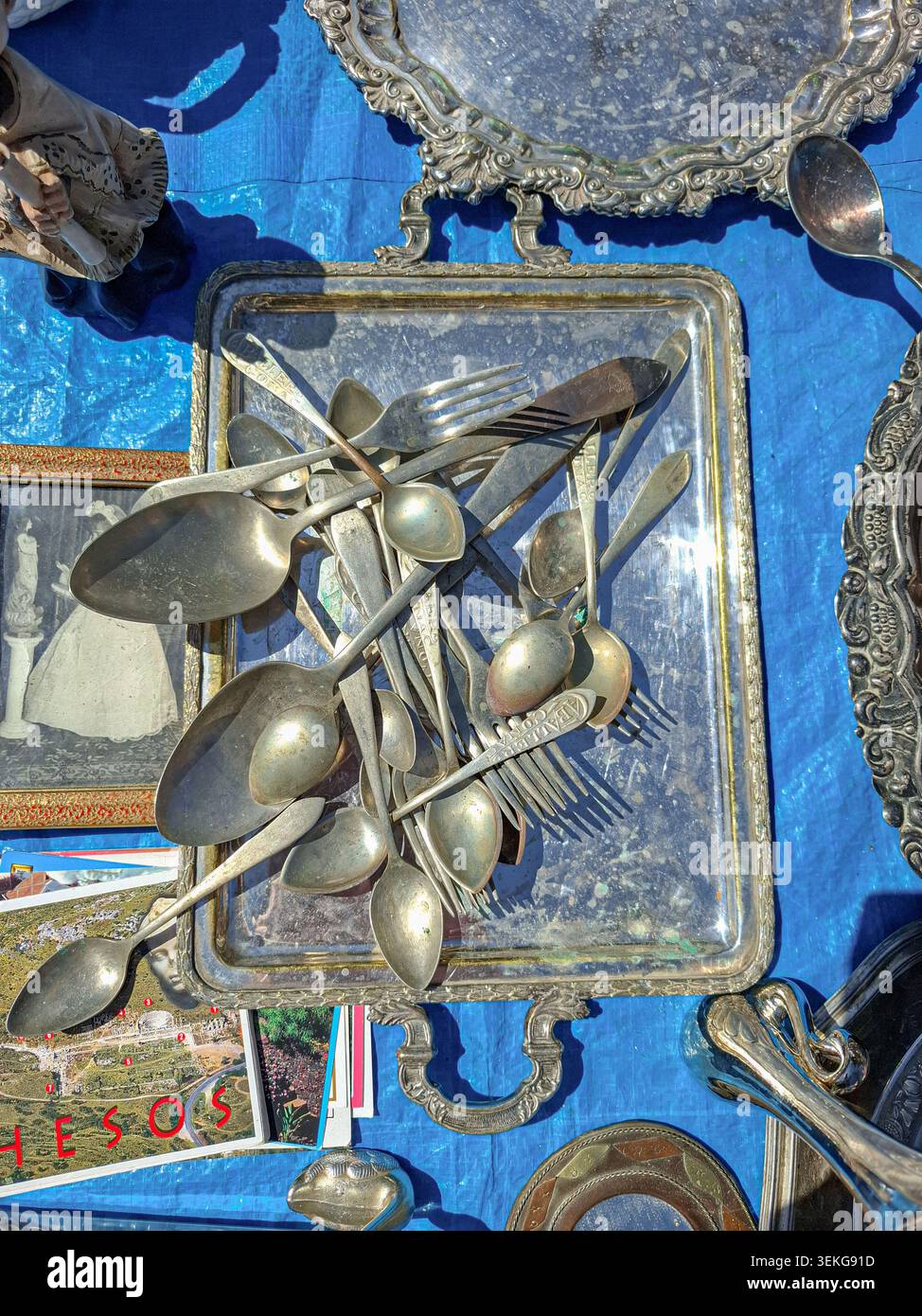 Polop, SPAGNA - 10 maggio 2026. L'argenteria Vintage è collocata su un classico vassoio d'argento in una bancarella del mercato delle pulci. La collezione comprende cucchiai appannati e. Foto Stock