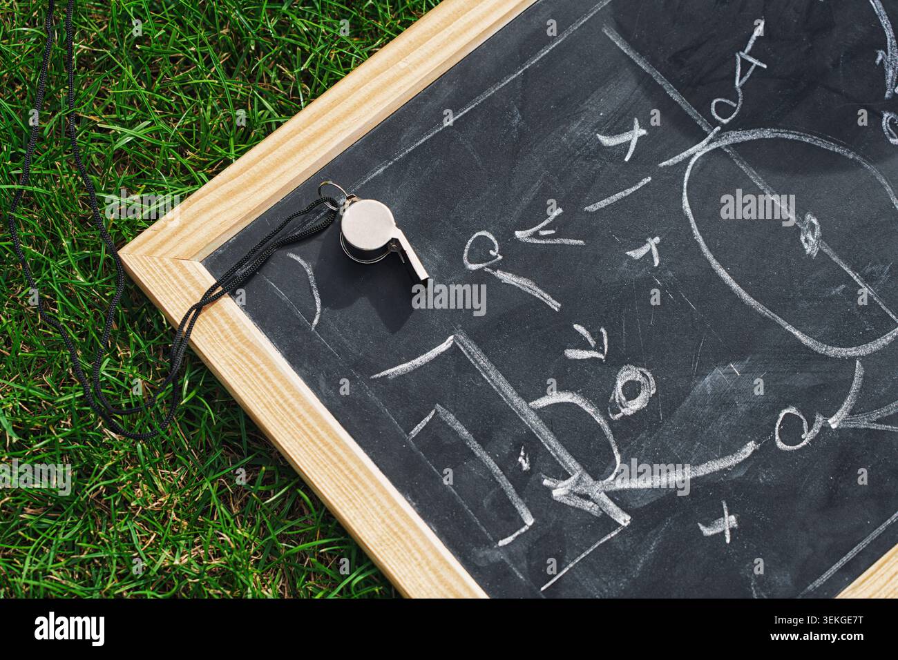 Piano di calcio tattico e fischio dell'arbitro. Schema di strategia disegnato a mano, isolato sulla lavagna nera. Foto Stock