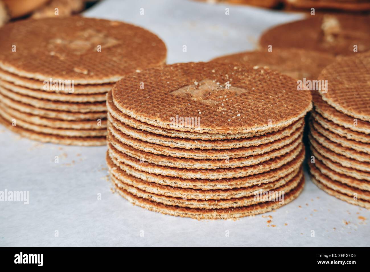 Stroopwafel olandesi appena sfornati impilati in pile ordinate, con consistenza croccante dei waffle e strati ripieni di caramello, ideali per la panificazione, il dessert e il mestiere Foto Stock
