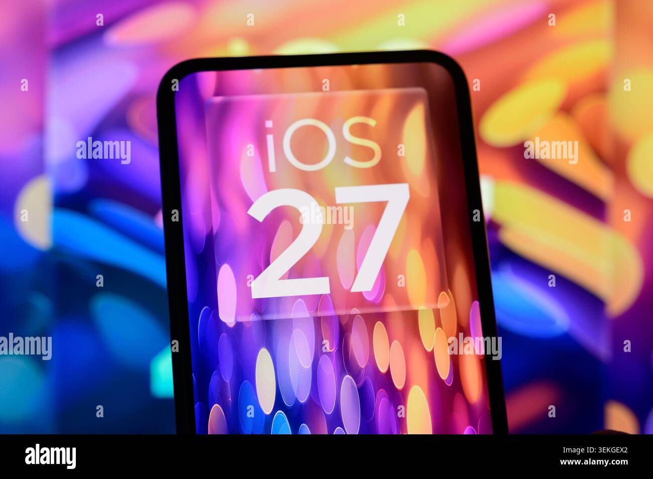 Parigi, Francia - 2 giugno 2026: Branding iOS 27 visualizzato sullo schermo di uno smartphone con uno sfondo bokeh colorato. Foto Stock