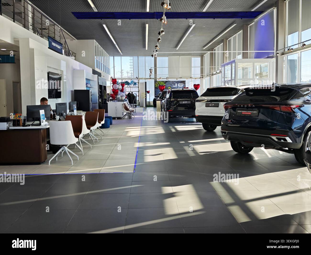 Perm, Russia - 5 marzo 2026: I clienti visitano un moderno showroom di vendita al dettaglio di automobili con veicoli OMODA in vendita. I concessionari assistono gli acquirenti con i loro Foto Stock