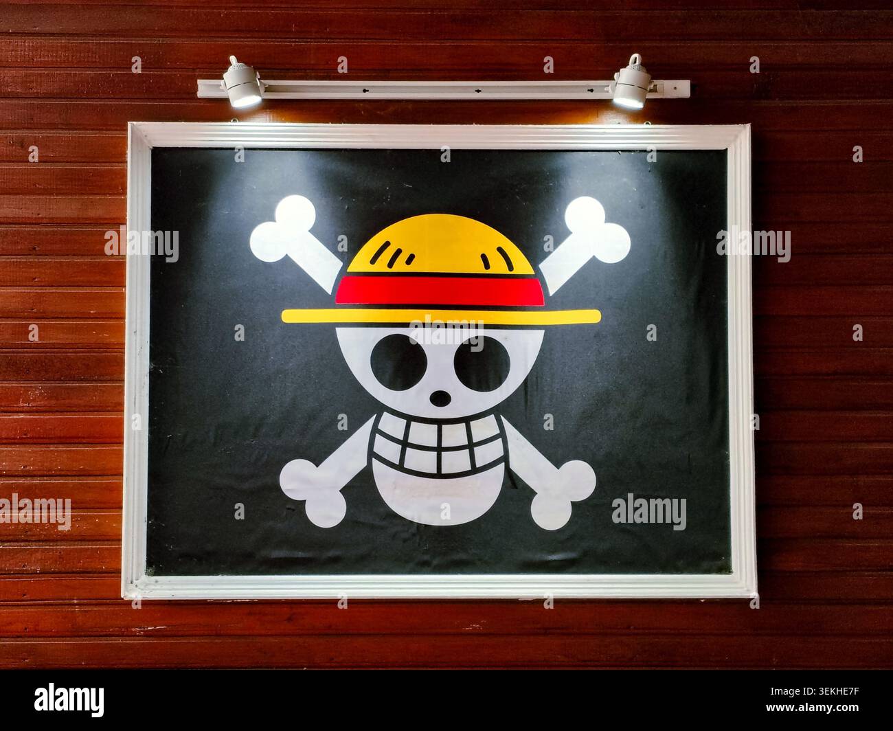 palu, Indonesia - 31 maggio 2026: Logo Jolly Roger incorniciato dei pirati del cappello di paglia dalla famosa serie manga e anime giapponese One Piece, esposto su una parete di pannelli di legno Foto Stock