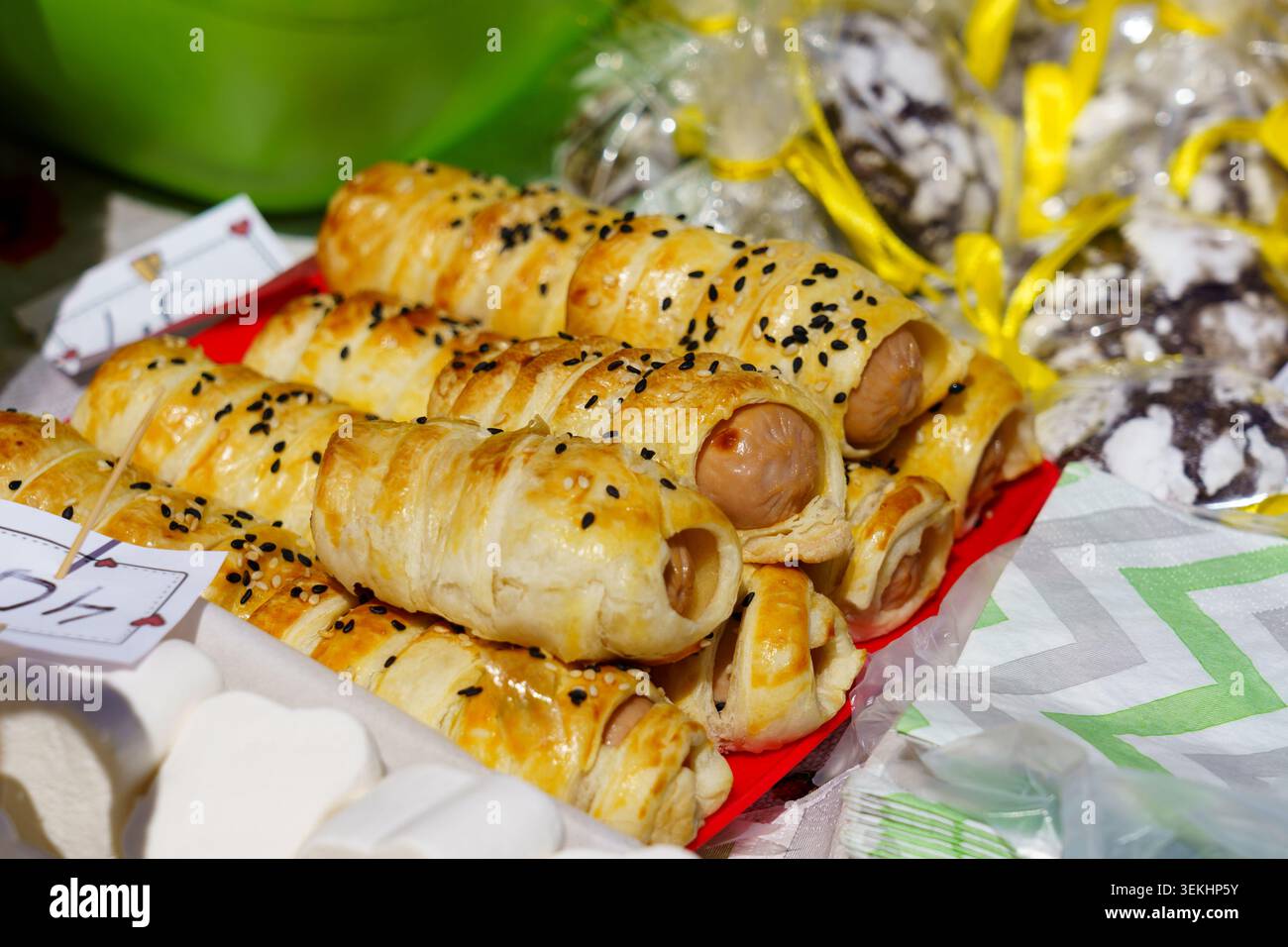 Spuntini appena sfornati presso un mercato locale con panini di salsiccia Foto Stock