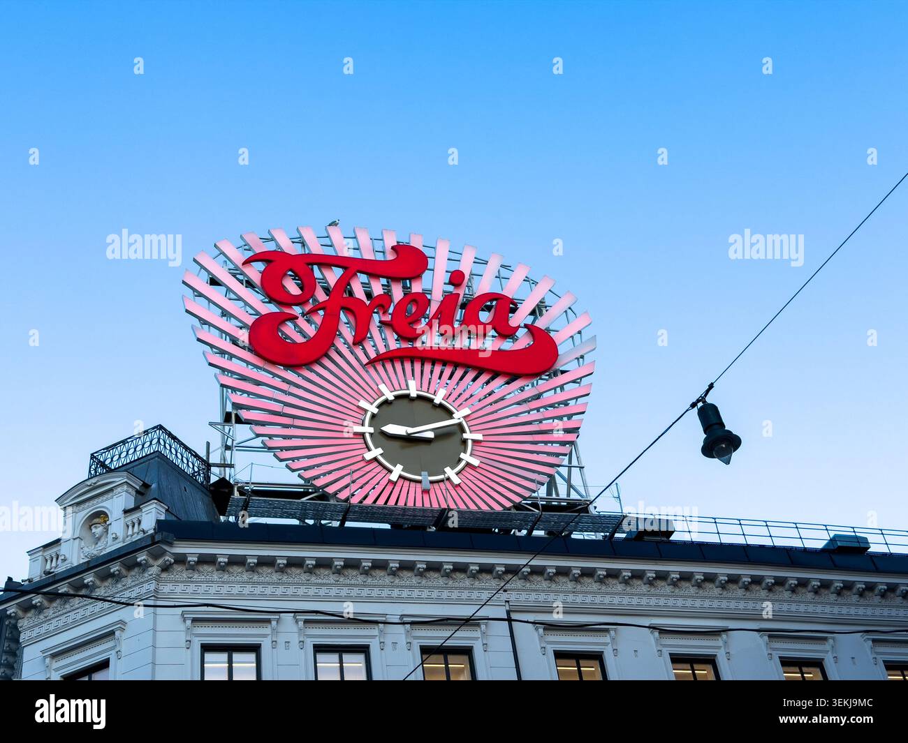 Storico cartello al neon di Freia e orologio sul tetto alla porta Karl Johans a Oslo, Norvegia - Immagine stock catturata con smartphone