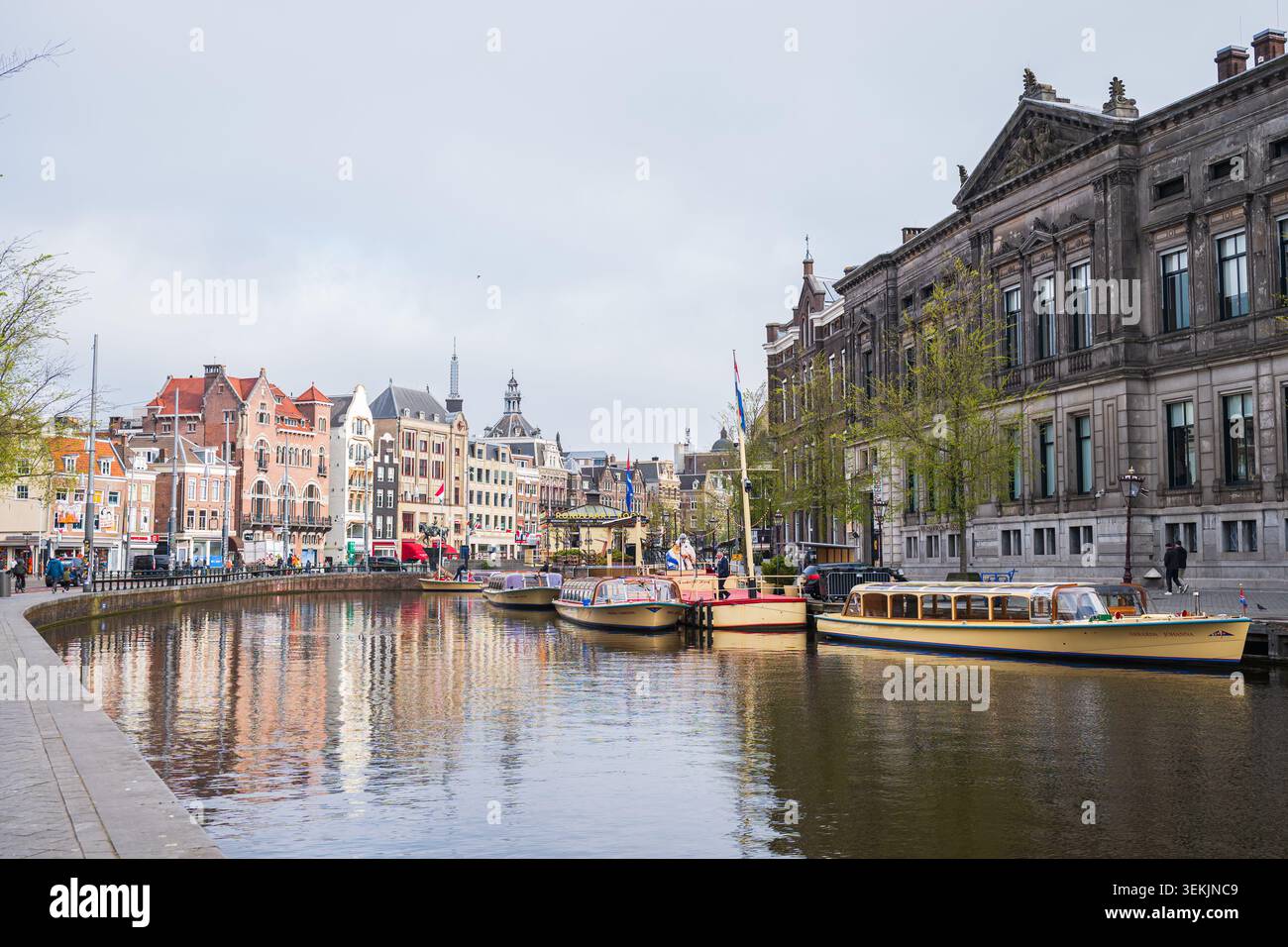 Amsterdam, Paesi Bassi, 22.04.2026 - splendida vista panoramica del canale di Amsterdam con edifici storici tradizionali, barche turistiche, riflessi sull'acqua Foto Stock