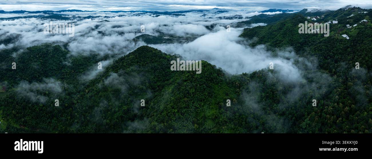 Un ampio paesaggio di lussureggianti montagne tropicali e densa foresta pluviale a mae Rim chiang mai caratterizzato da nuvole che si snodano sugli altopiani. Foto Stock