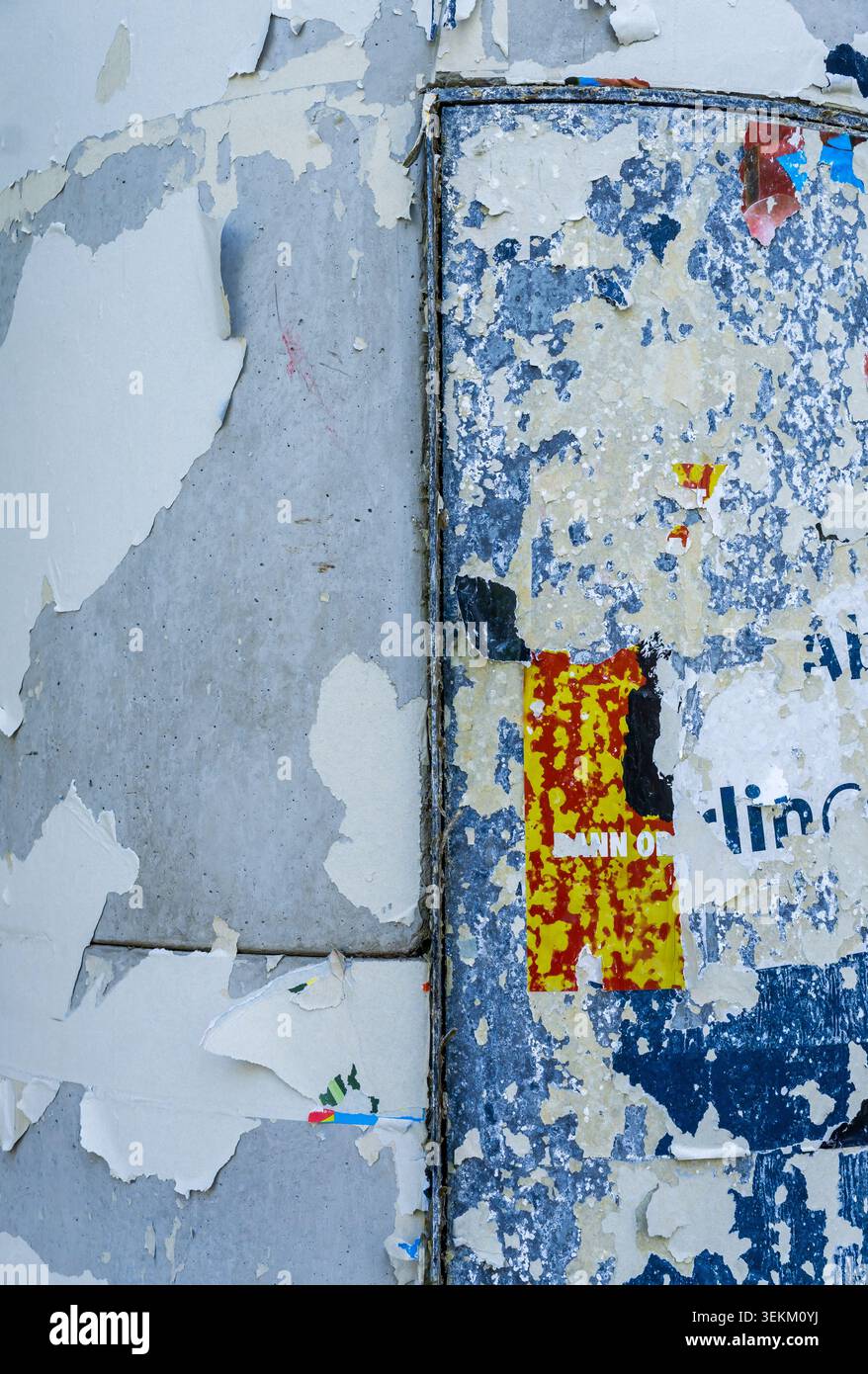 Primo piano di resti di poster intemprati e vernice sbucciata su una colonna pubblicitaria urbana. Superficie in rilievo con trame di carta stratificate, dettagli grunge. Foto Stock