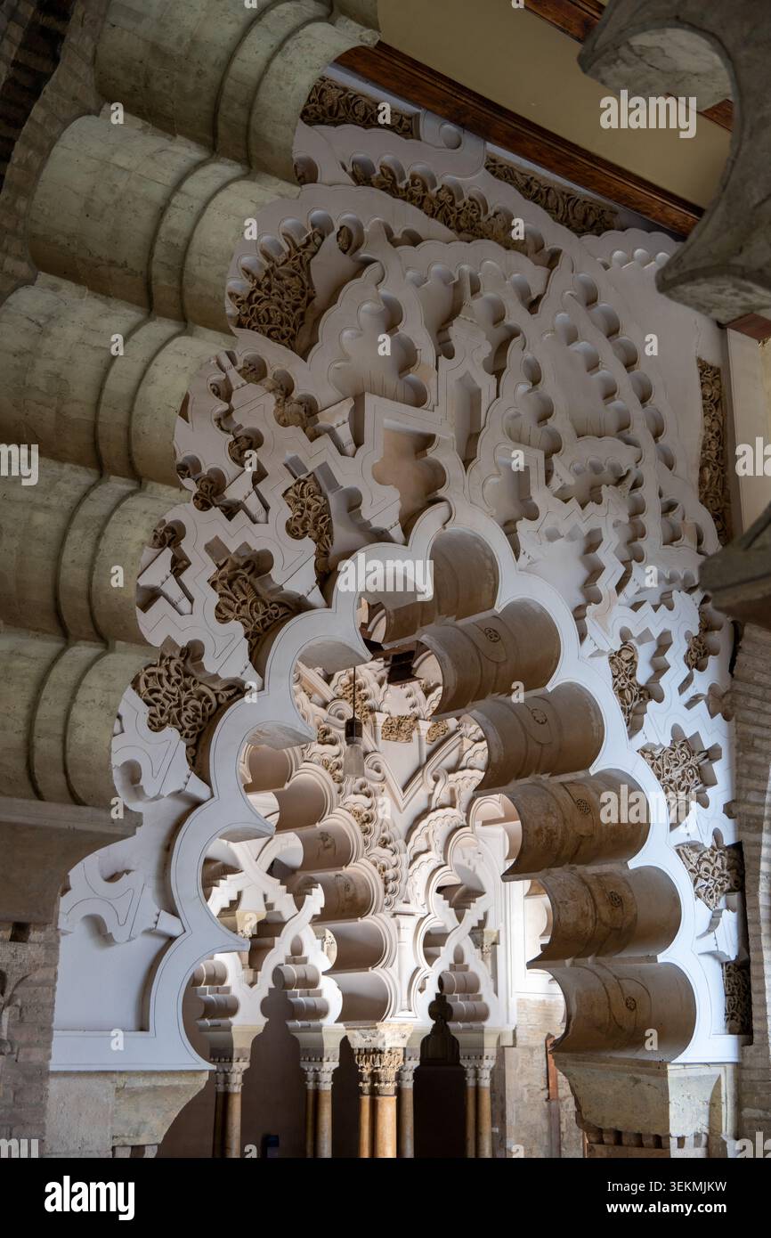 Vista ravvicinata di intricati archi moreschi e ornamenti scolpiti all'interno del Palacio de la Aljaferia, Saragozza, Spagna. Foto Stock