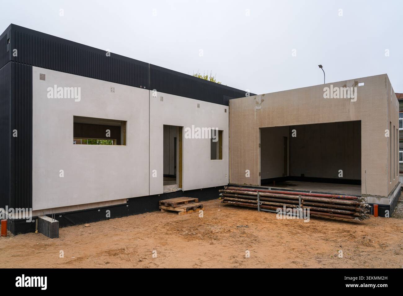 Moderno edificio residenziale in costruzione con facciata minimalista e struttura a garage aperto Foto Stock