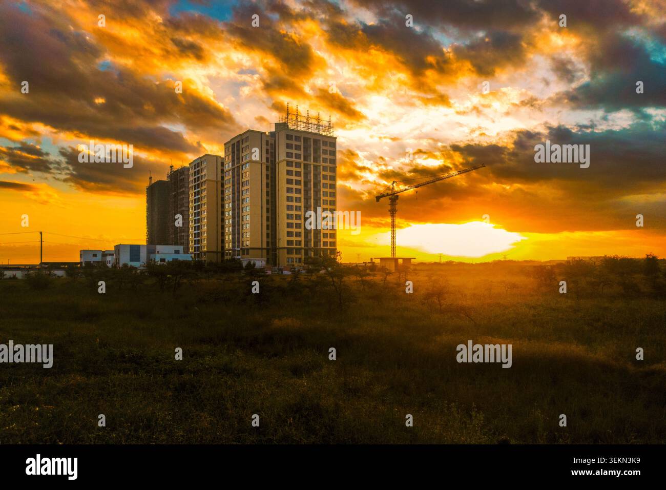 Silhouette di Construction Crane e Building sotto il suggestivo cielo del tramonto a Syokimau, Kenya Foto Stock
