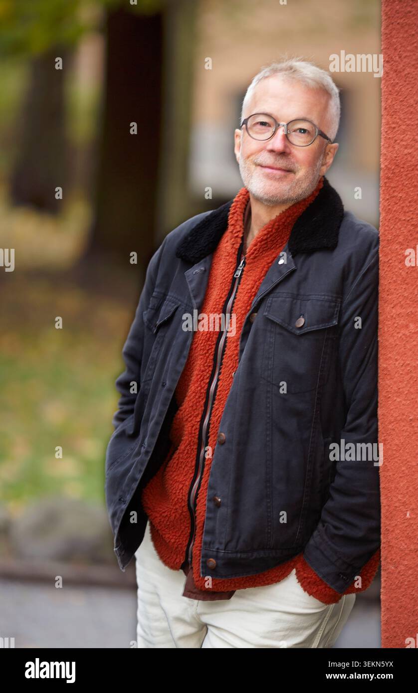 Ritratto di un anziano sorridente appoggiato al muro Foto Stock