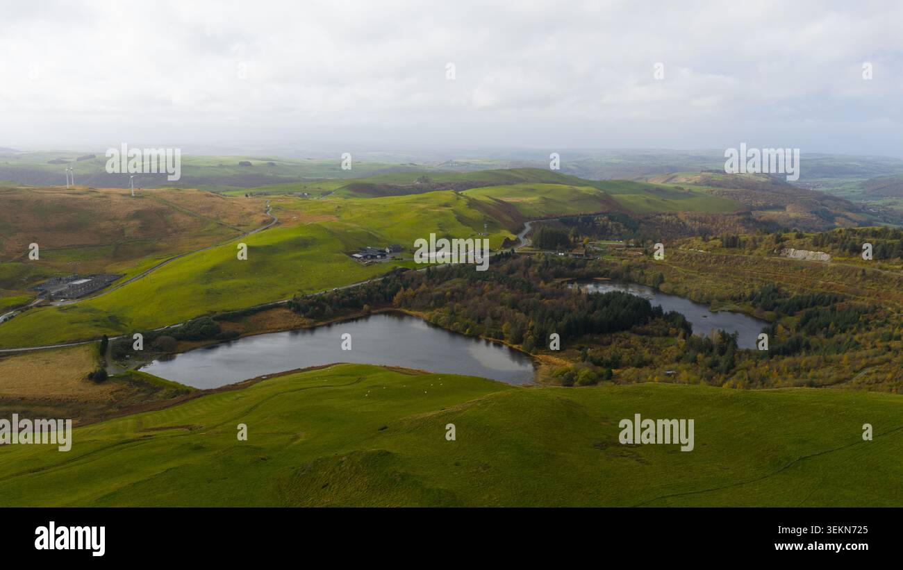 Vista aerea delle ondulate colline gallesi, dei laghi acquatici delle turbine eoliche Foto Stock