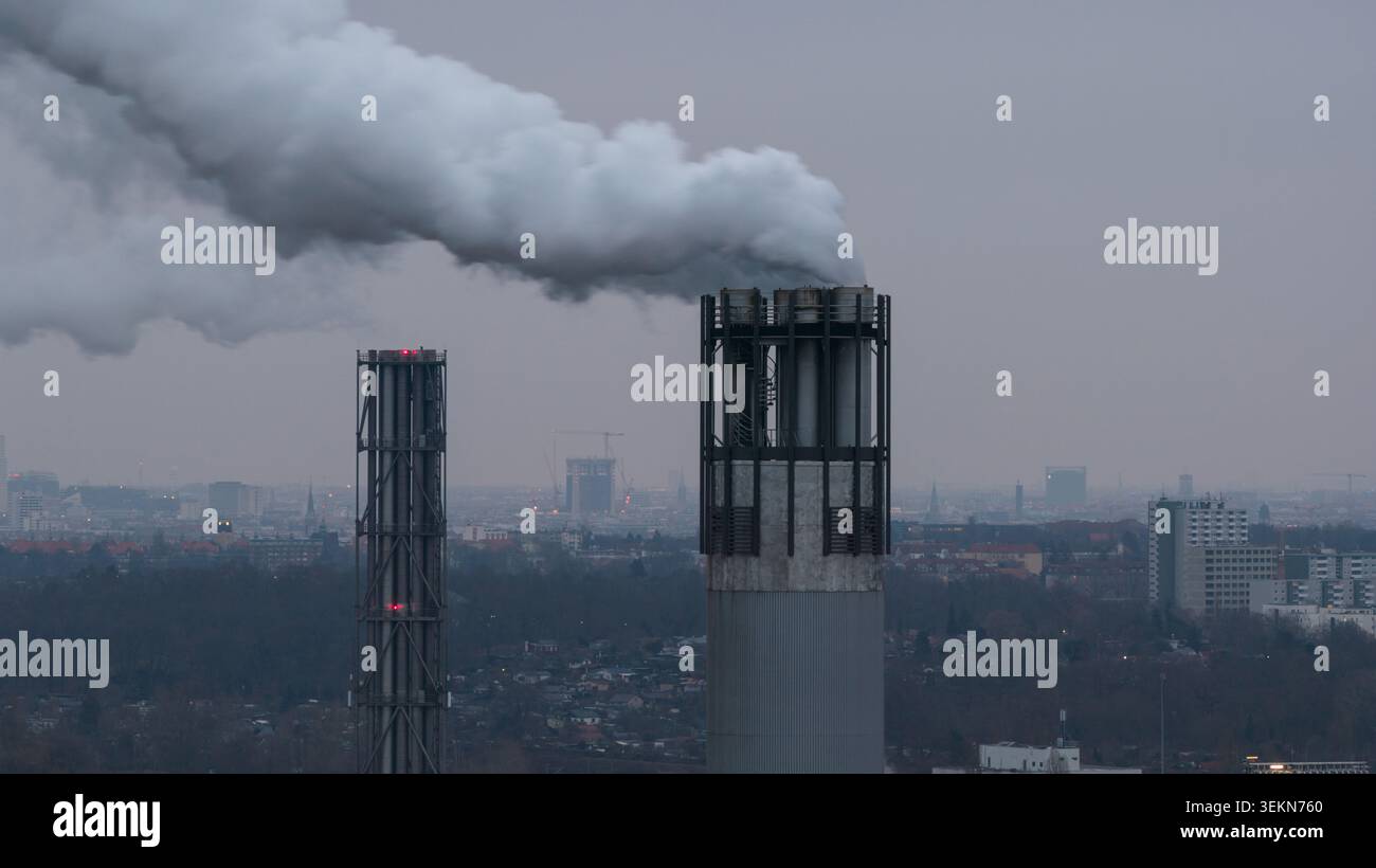 Le ciminiere industriali emettono fumo intenso nell'aria della città Foto Stock