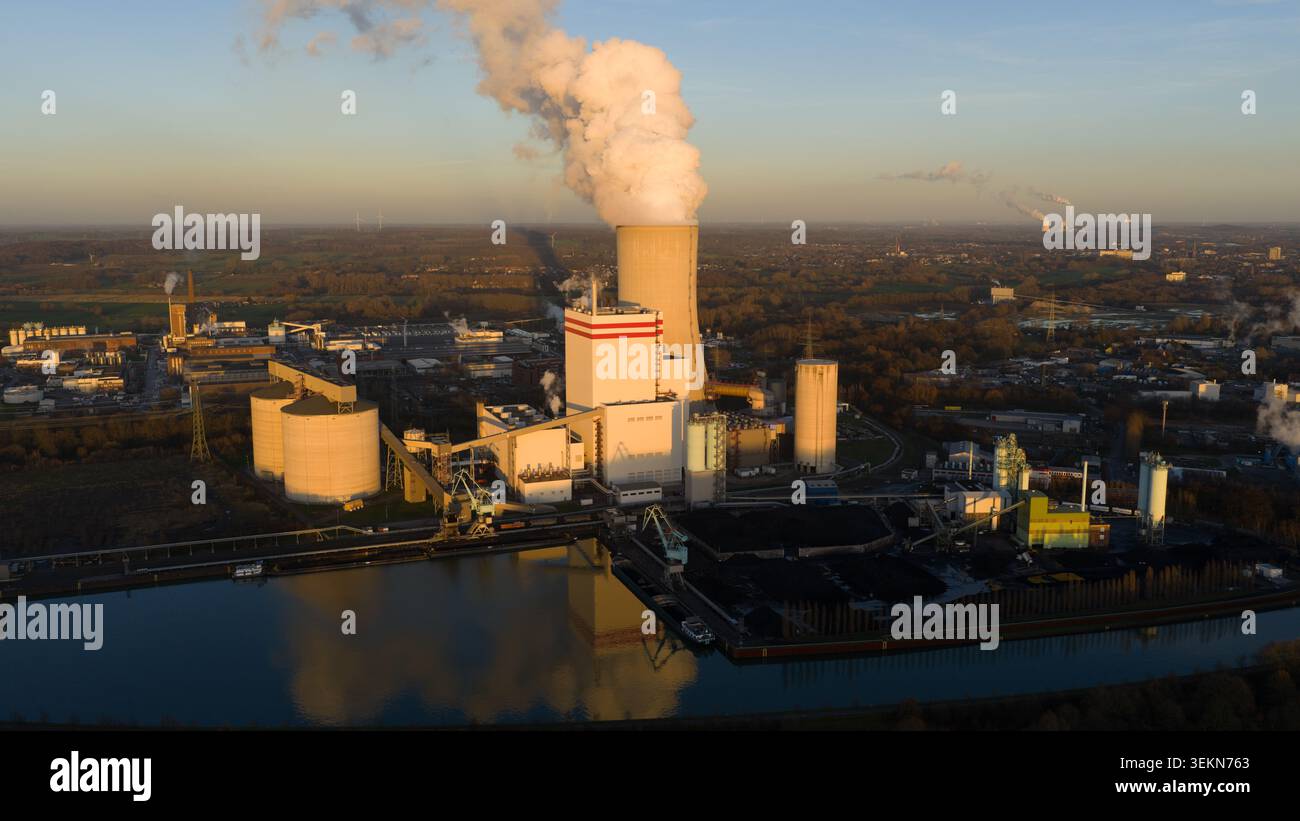 Centrale elettrica industriale che emette fumo al tramonto Foto Stock
