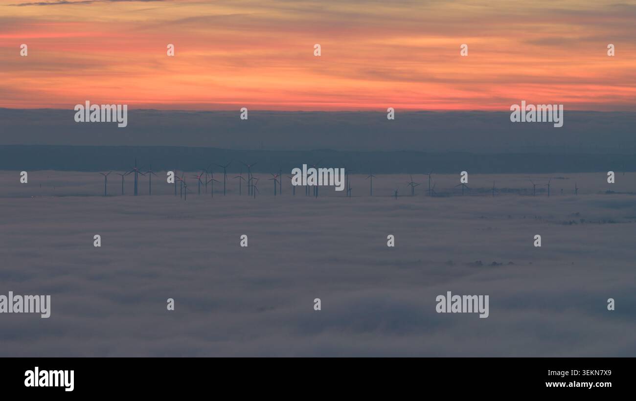 Turbine eoliche alte sopra un mare di nebbia al tramonto Foto Stock