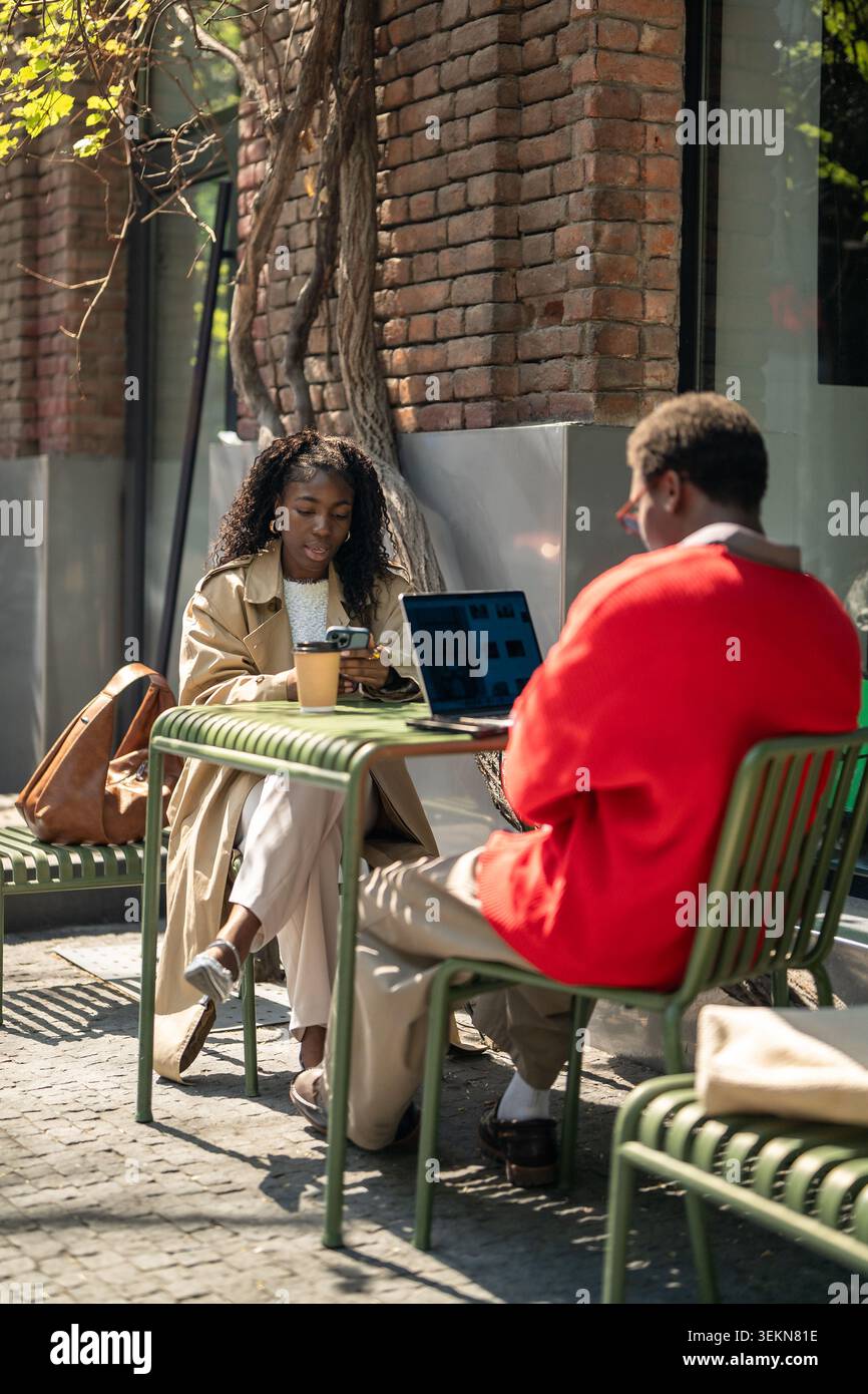Amici afroamericani alla moda che trascorrono una giornata di pausa in un bar di strada Foto Stock