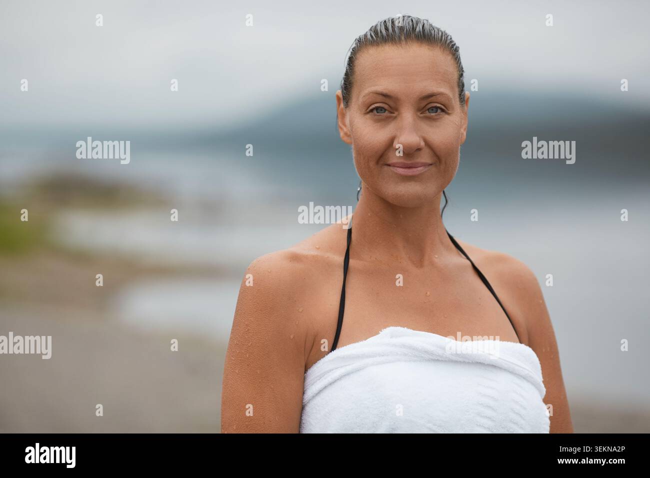 Ritratto di donna sorridente avvolto in asciugamano Foto Stock