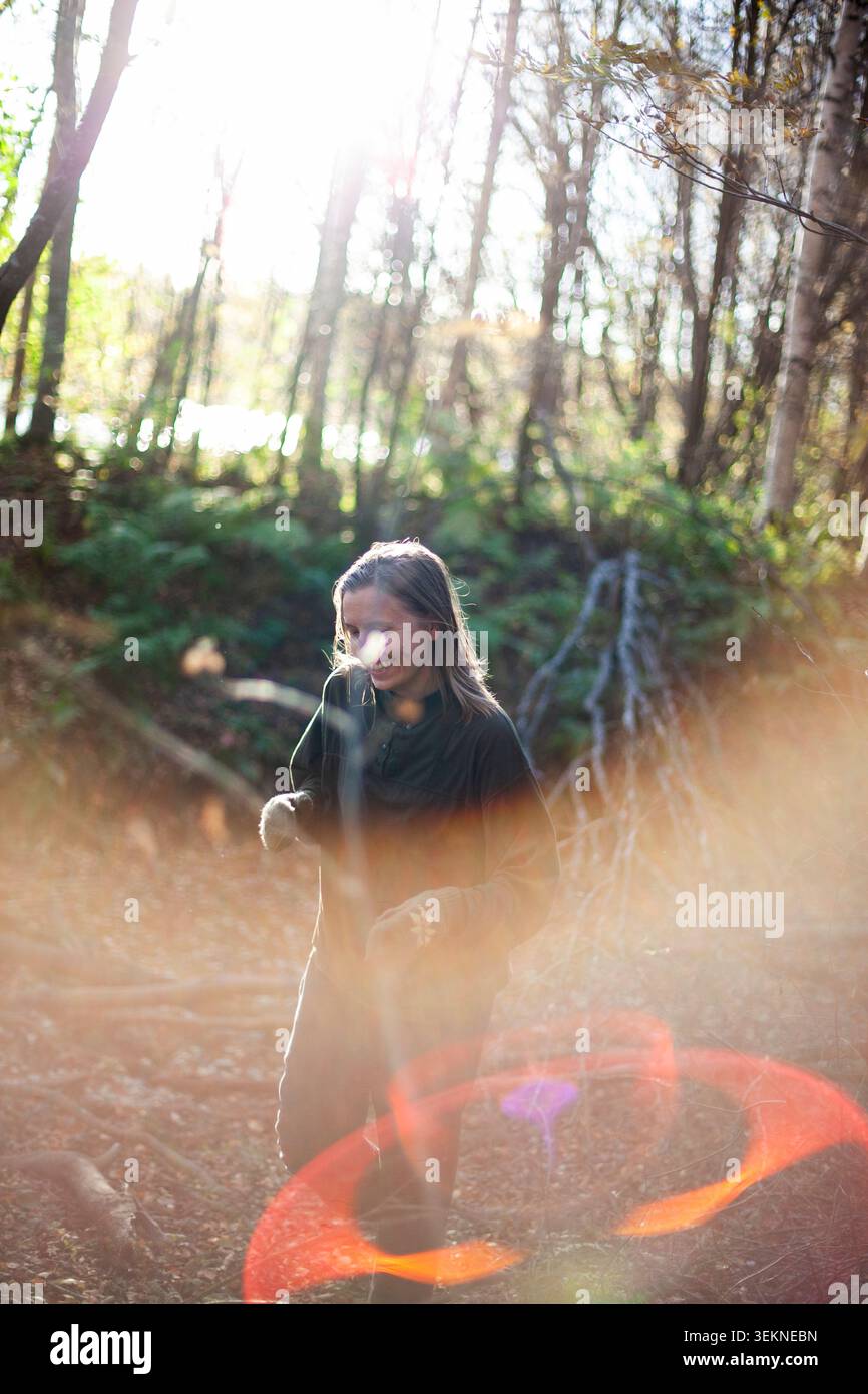 Donna sorridente che passa il tempo libero nella foresta Foto Stock