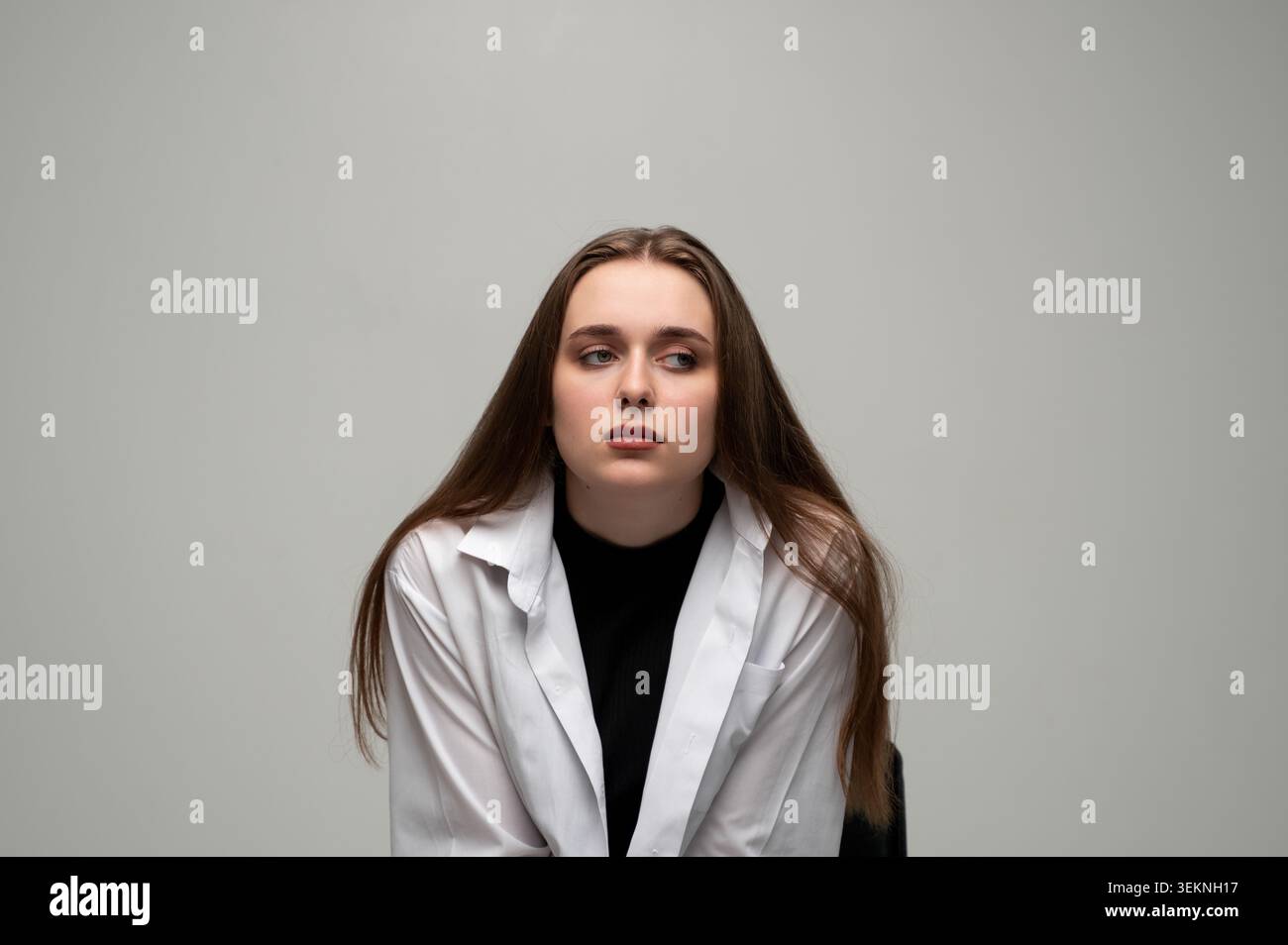 Giovane donna che si sente triste e preoccupata, soffre di depressione, solitudine e problemi di salute mentale, guardando lontano nel pensiero profondo Foto Stock