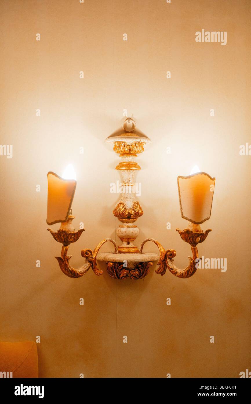 Applique decorativa in stile tradizionale che illumina le camere d'hotel. Concetto di comfort ed eleganti soluzioni di illuminazione. Foto Stock