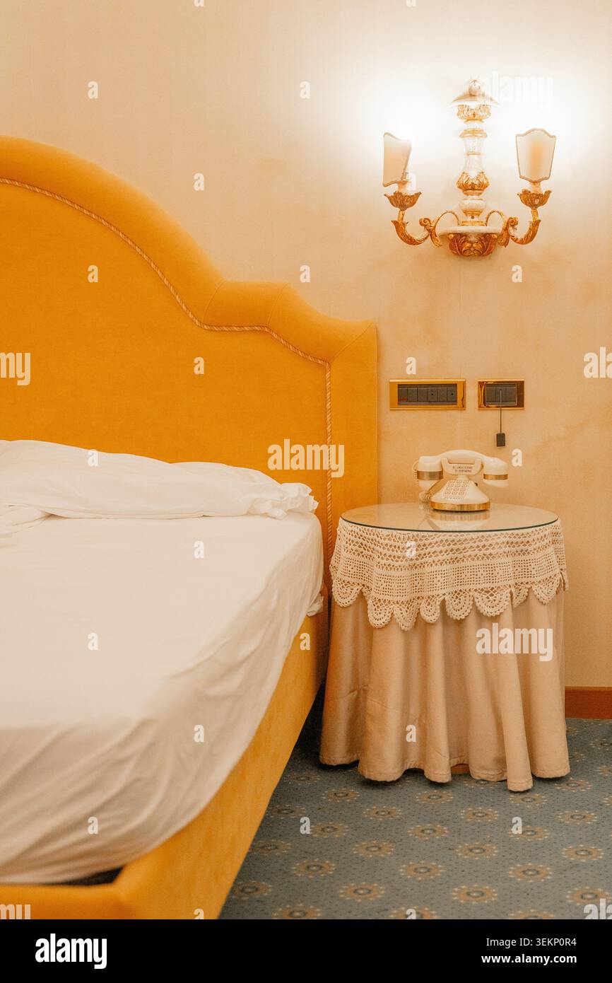 Camera da letto in stile vintage con illuminazione soffusa e dettagli decorativi. Concetto di comfort, relax e design tradizionale europeo degli interni. Foto Stock