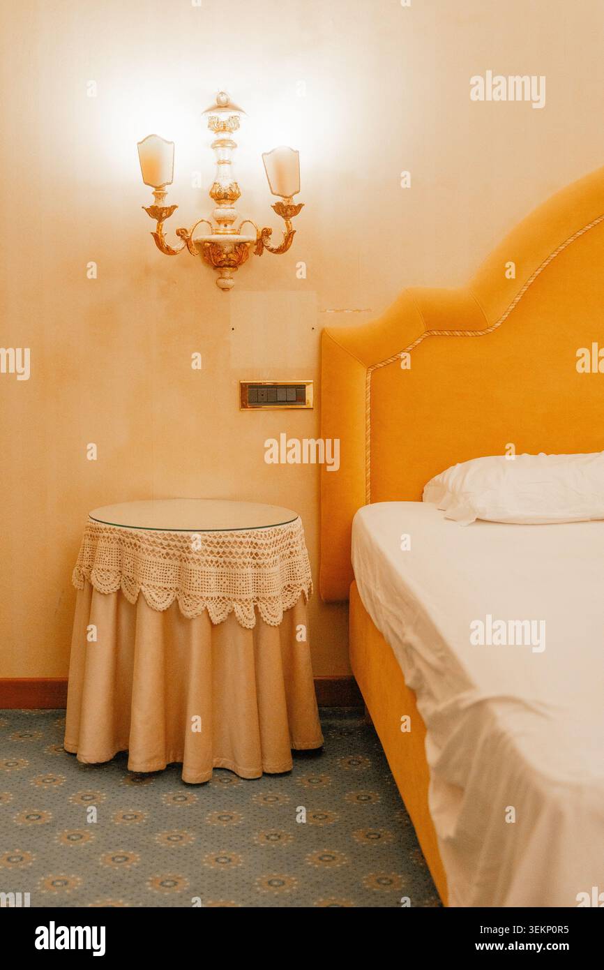 Angolo camera da letto in stile classico con mobili decorativi e illuminazione soffusa. Concetto di comfort ed estetica degli interni senza tempo. Foto Stock