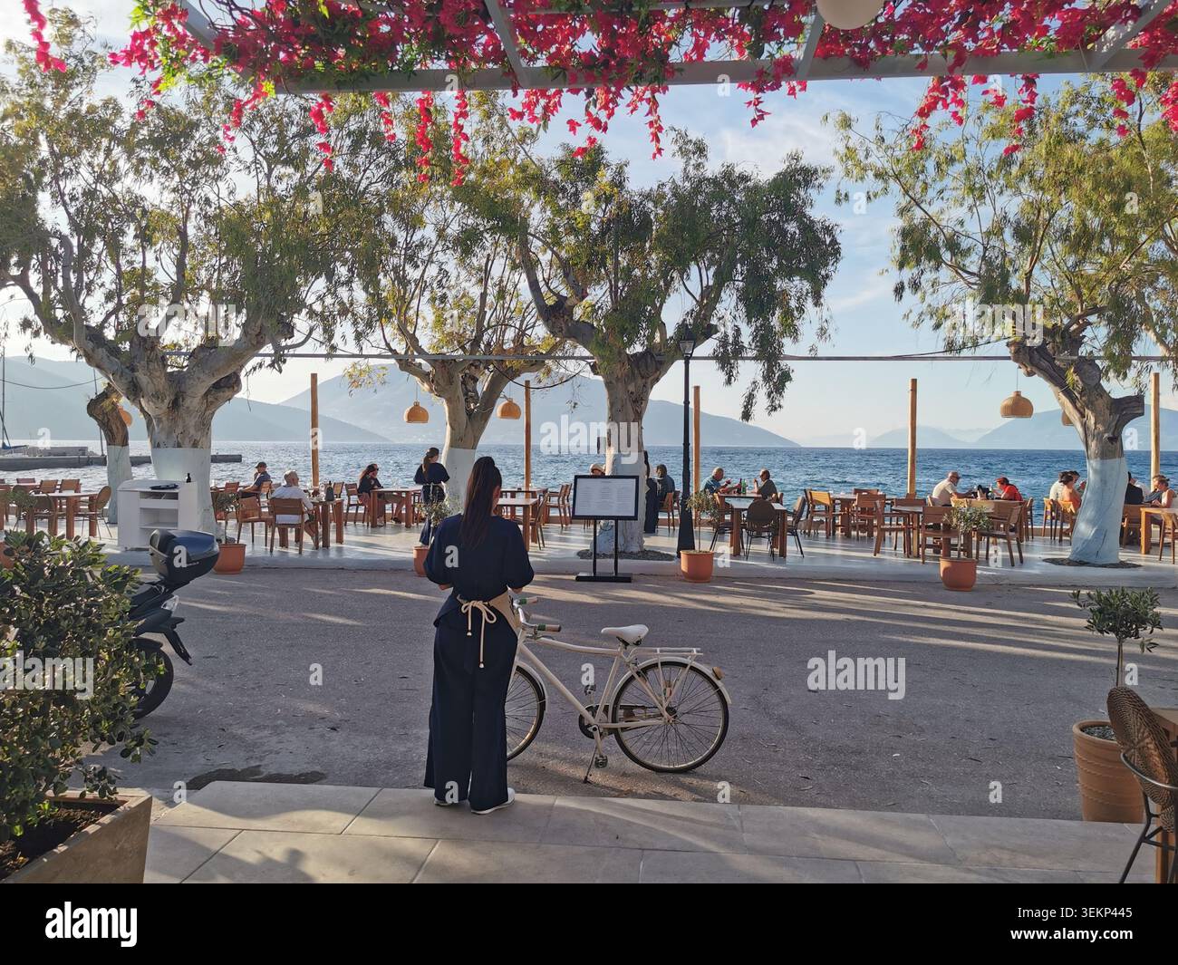 Bella taverna, Sami, Cefalonia. Taverna sul lungomare di Familia al crepuscolo sul porto di Sami con viste mozzafiato di Itaca. - Immagine stock catturata con smartphone