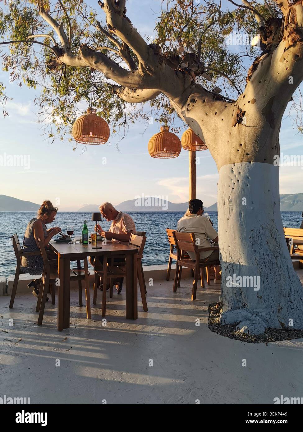 Bella taverna, Sami, Cefalonia. Taverna sul lungomare di Familia al crepuscolo sul porto di Sami con viste mozzafiato di Itaca. - Immagine stock catturata con smartphone