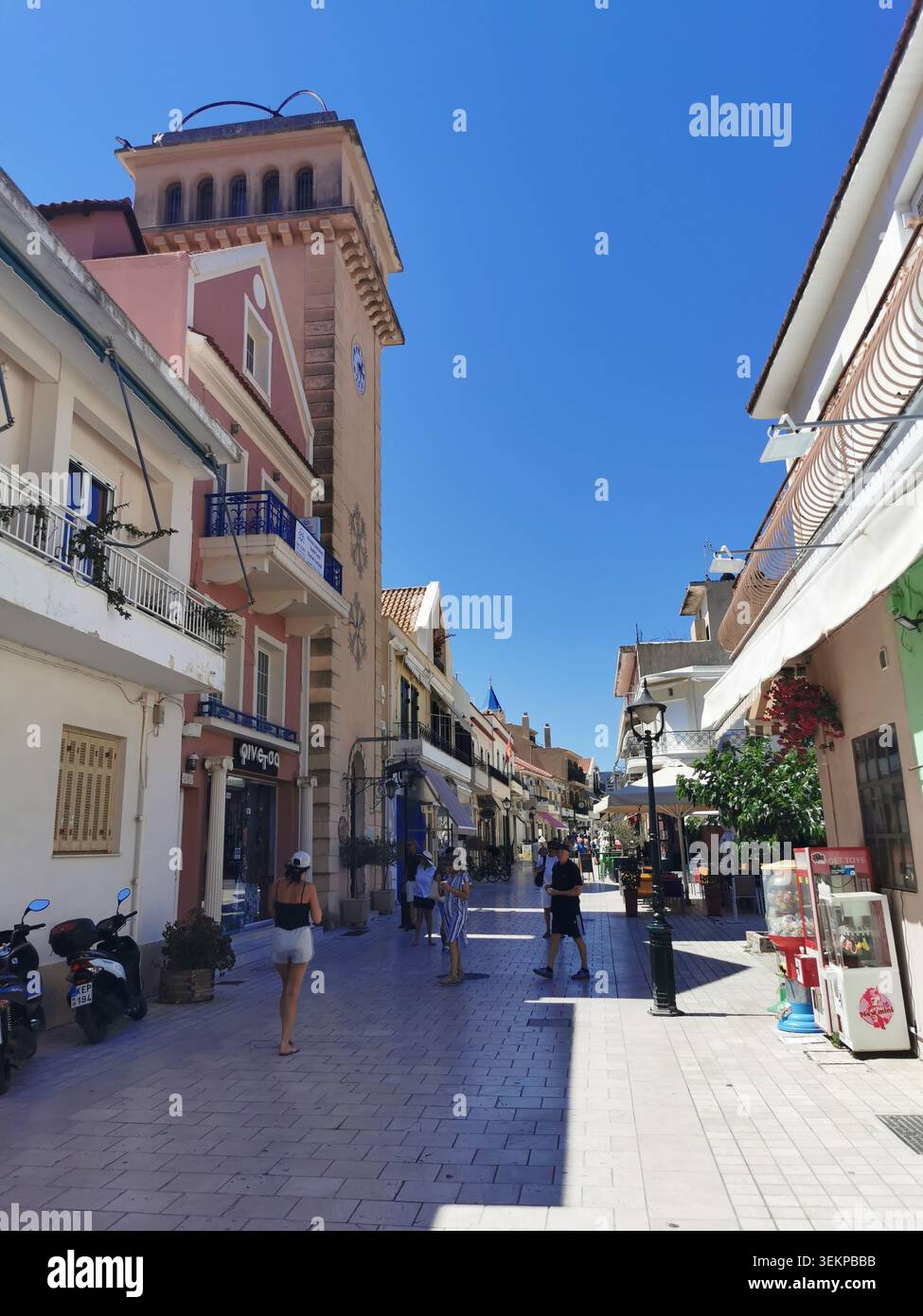 Lithostroto, strada pedonale per lo shopping ad Argostoli, Cefalonia, Grecia. Caffetterie tradizionali, boutique locali e foto del campanile di Kampana. - Immagine stock catturata con smartphone