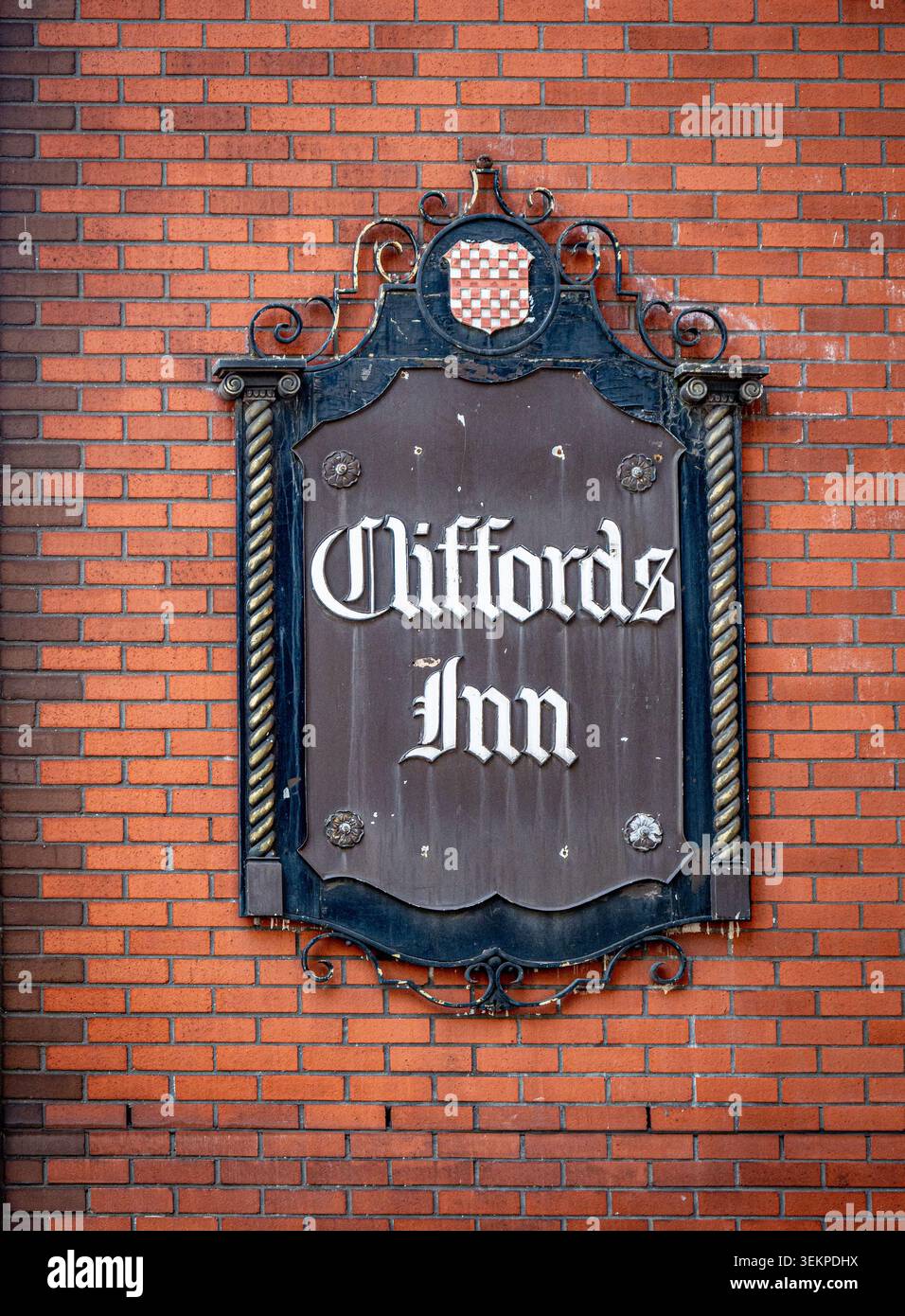 Il nome del Clifford's Inn, montato su un muro di mattoni rossi, un edificio storico situato in Fetter Lane a Londra, Inghilterra. Foto Stock
