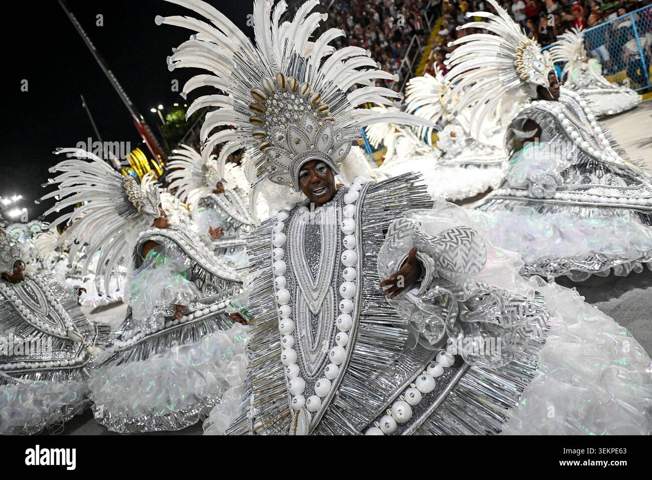 RIO DE JANEIRO, BRASILE - 17 FEBBRAIO: I membri della scuola di Samba si esibiscono in elaborati costumi bianchi e argentati con grandi copricapi piuma e sh Foto Stock