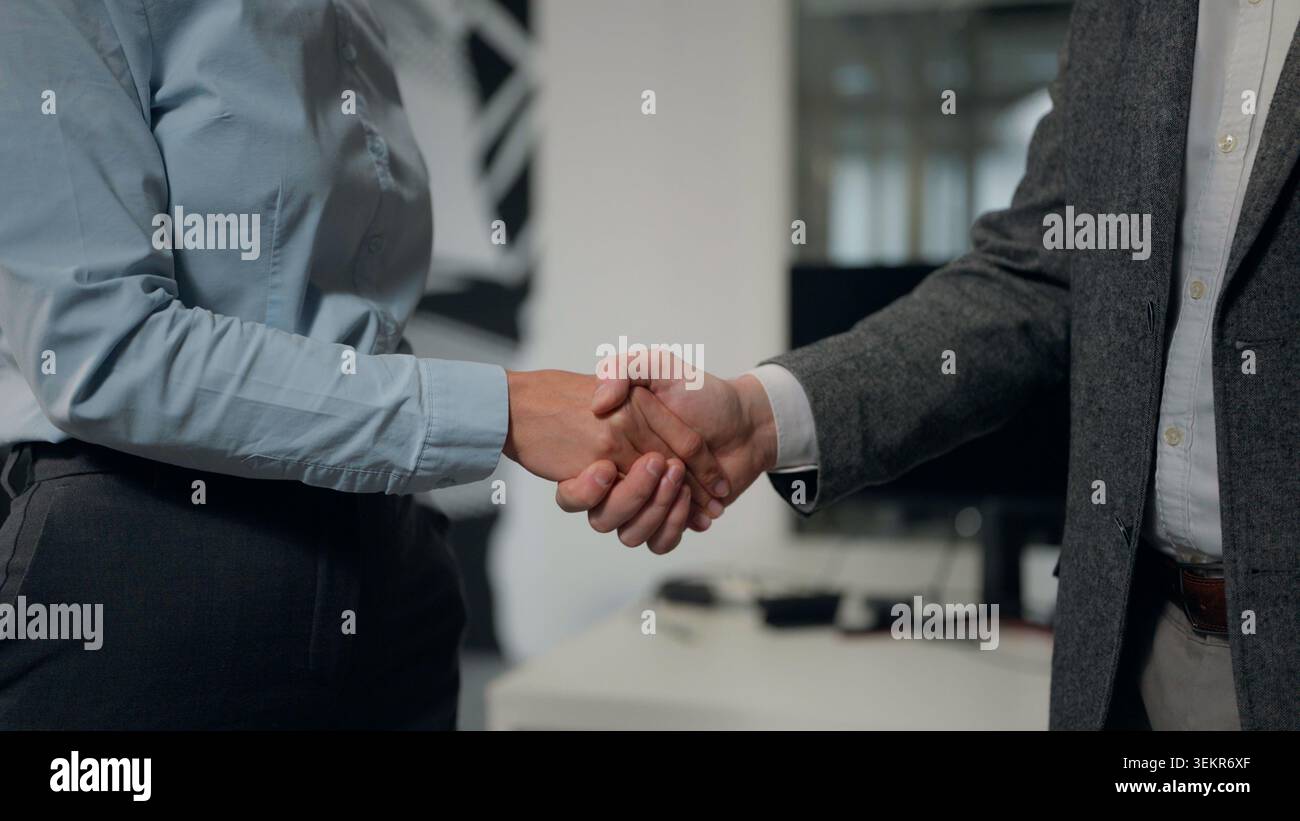 Stretta di mano d'affari donna con uomo stretta di mano in collaborazione con uffici aziendali assumendo lavoro due partner irriconoscibili donna con uomo Foto Stock