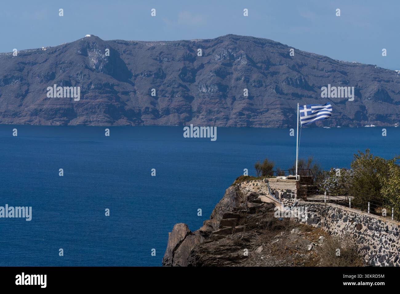 Bandiera greca che sventola sulla riva del Mar Egeo a Fira, Santorini. Foto Stock