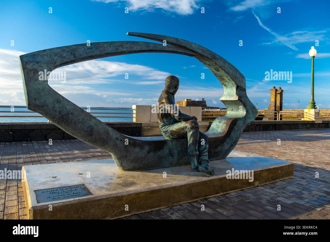 Arrecife, Lanzarote, Isole Canarie, Spagna - 23 maggio 2026: Una scultura in bronzo di Cesar Manrique presenta una figura seduta, situata lungo il lungomare Foto Stock