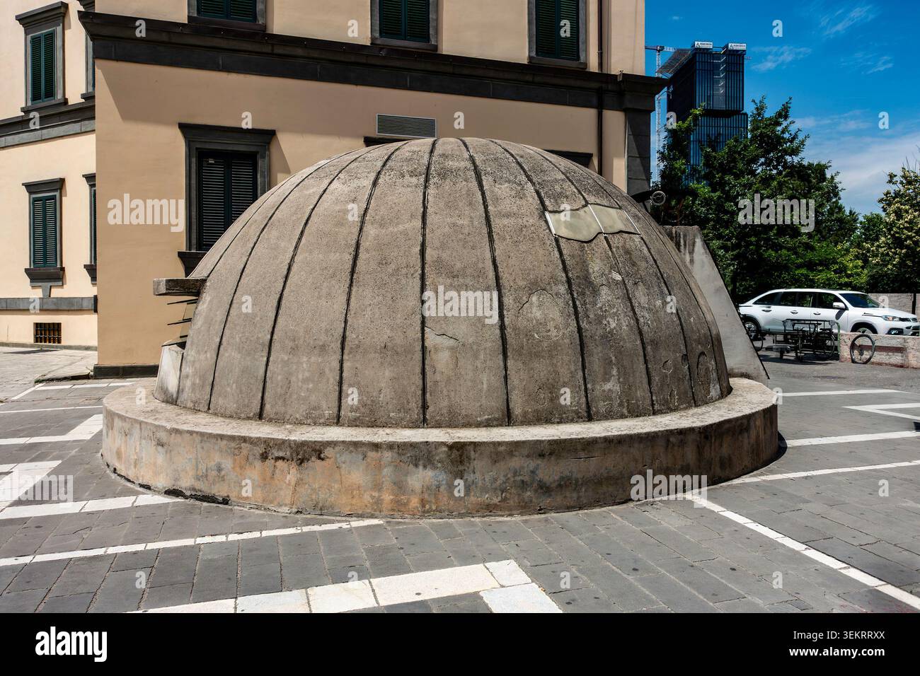 La cupola in cemento dell'ingresso del museo Bunk'Art 2 si trova in un cortile pavimentato vicino a un edificio governativo sotto un cielo blu a Tirana, Albania. Foto Stock