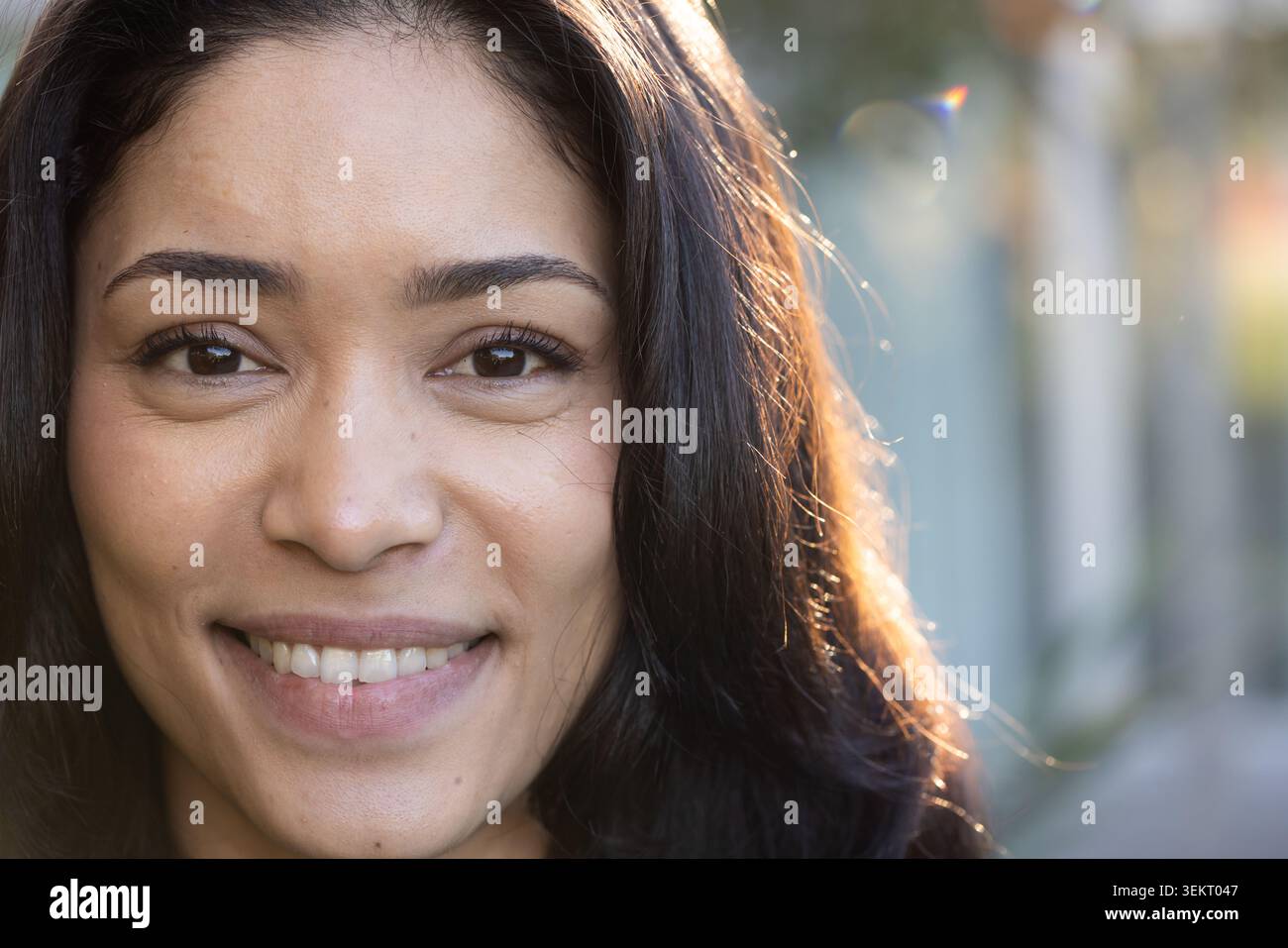 Donna negli anni '30 che sorride, si dirige verso la calda luce solare del bordo sul vialetto con la lente flare bokeh Foto Stock