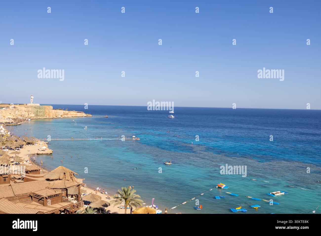 Costa panoramica del Mar Rosso a Sharm El Sheikh, Egitto, con spiaggia di acque turchesi, servizi da resort e visitatori che si godono l'ambiente sul mare Foto Stock
